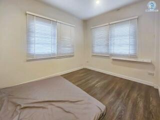 Bedroom with blinds on windows and wooden floor