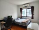 Bedroom with a bed, desk, computer, window, air conditioner, and wooden floor