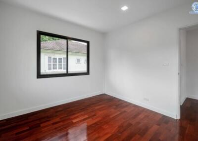 Empty bedroom with wooden floor and a large window