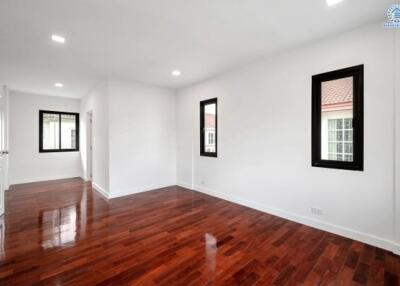 Empty living space with wooden flooring and windows