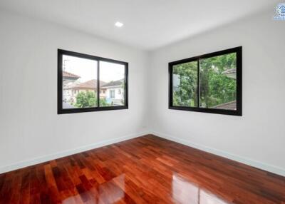 empty bedroom with wooden floor and large windows