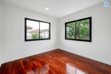 empty bedroom with wooden floor and large windows