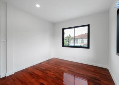 Empty bedroom with wooden floor and window