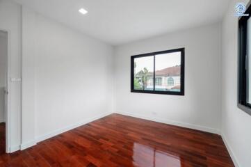 Empty bedroom with wooden floor and window