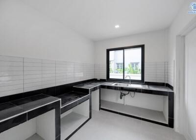 Modern kitchen with black countertops and white tiled backsplash