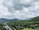 Scenic view of hills and greenery with cloudy sky