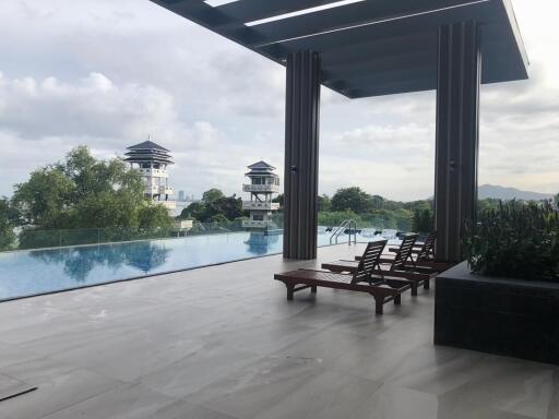 Outdoor pool area with lounge chairs and scenic view