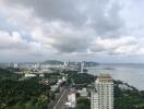 Aerial view of the city with buildings, greenery, and ocean