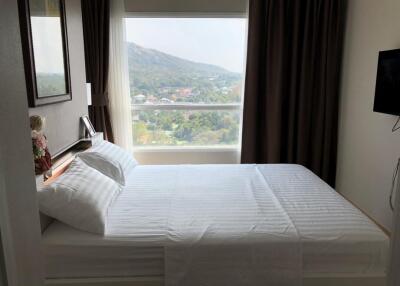 Bedroom with a large window and mountain view