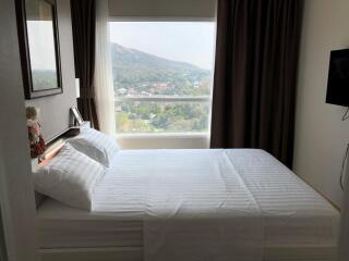 Bedroom with a large window and mountain view