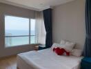 Cozy bedroom with a large window offering an ocean view