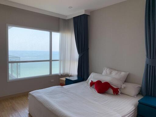 Cozy bedroom with a large window offering an ocean view