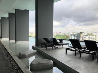 Outdoor pool area with lounge chairs and city view