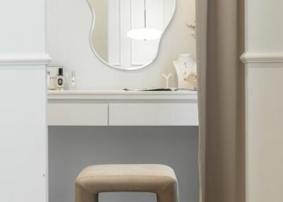 Dressing table with abstract mirror and beige stool