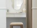 Dressing table with abstract mirror and beige stool