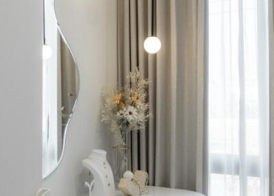 Cozy bedroom vanity corner with modern mirror and hanging lights