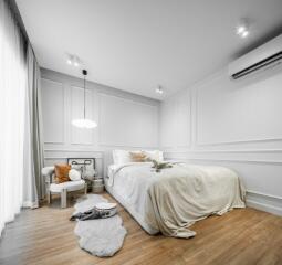 Cozy modern bedroom with white bedding and wooden flooring