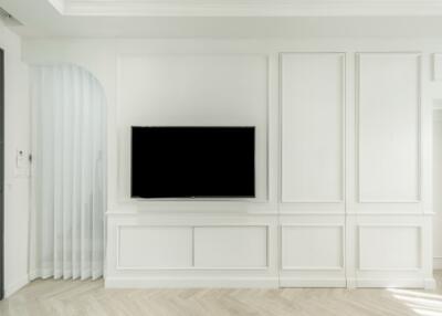 Minimalist living room with white paneled walls and wall-mounted TV