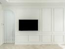 Minimalist living room with white paneled walls and wall-mounted TV