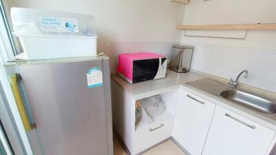 Compact kitchen with refrigerator, microwave, and sink