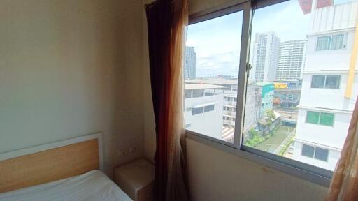 Bedroom with window view of city buildings
