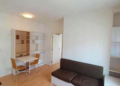 Living room with sofa, table, chairs, and bookshelves