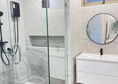 Modern bathroom with glass shower and round mirror