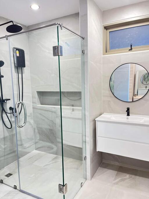 Modern bathroom with glass shower and round mirror