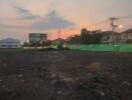 Vacant land during sunset with nearby infrastructure