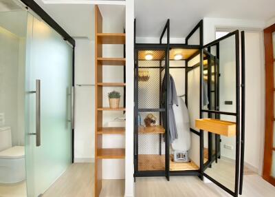 Modern bathroom with glass shower, open shelving, and storage area