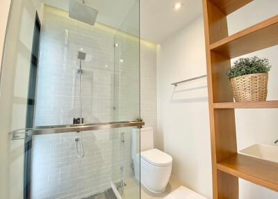 Modern bathroom with glass shower and wooden shelving