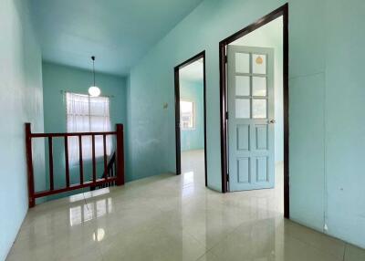 Spacious hallway with light blue walls and a staircase