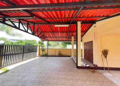 Covered outdoor area with red roof and tiled floor