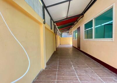 Narrow hallway with tiled floor and windows