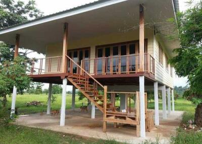 Elevated house with wooden balcony and stairs