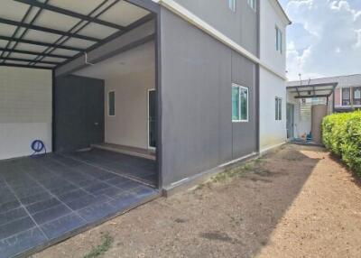 Exterior view of a residential building with a garage and a backyard