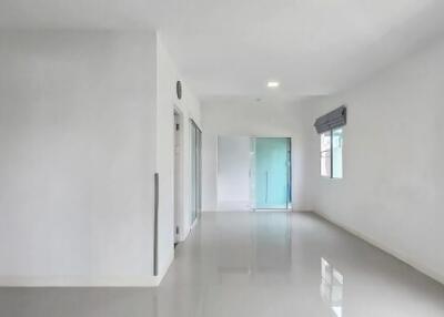 Empty hallway with glossy floor tiles and windows