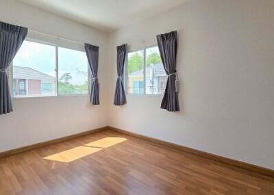 Bright and spacious bedroom with wooden flooring and large windows