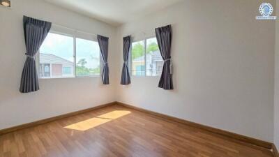 Bright and spacious bedroom with wooden flooring and large windows