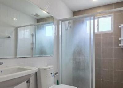 Modern bathroom with toilet, sink, and shower