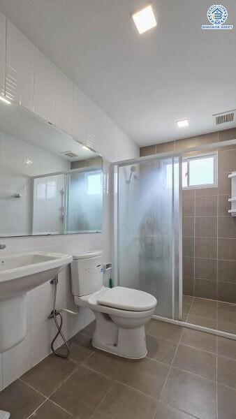 Modern bathroom with toilet, sink, and shower