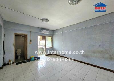 Living area with tiled floor, window, air conditioning, and access to bathroom