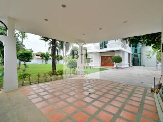 Covered outdoor patio with a view of garden and building entrance