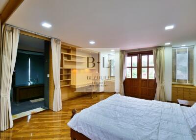 Spacious bedroom with wooden flooring and adjoining bathroom