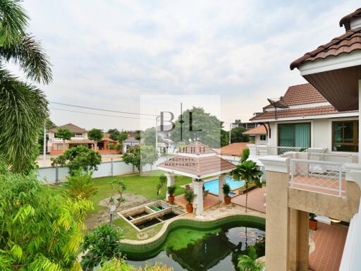 Exterior view of a large house with a swimming pool and garden area