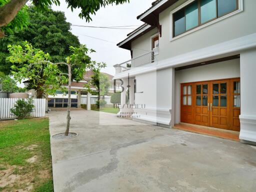 Exterior view of a house with a paved driveway and trees