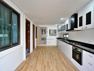 Spacious modern kitchen with sleek appliances and wooden flooring