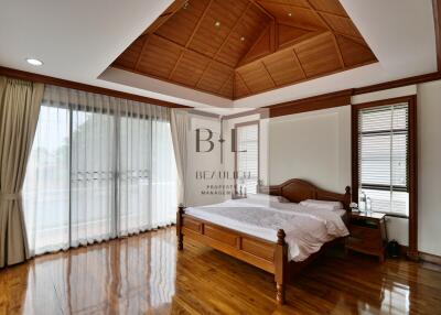 Spacious bedroom with wooden ceiling and floor