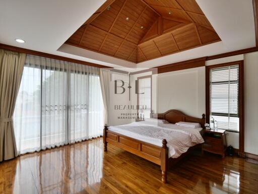 Spacious bedroom with wooden ceiling and floor