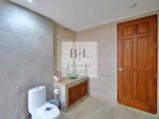 Modern bathroom with wooden door and large mirror